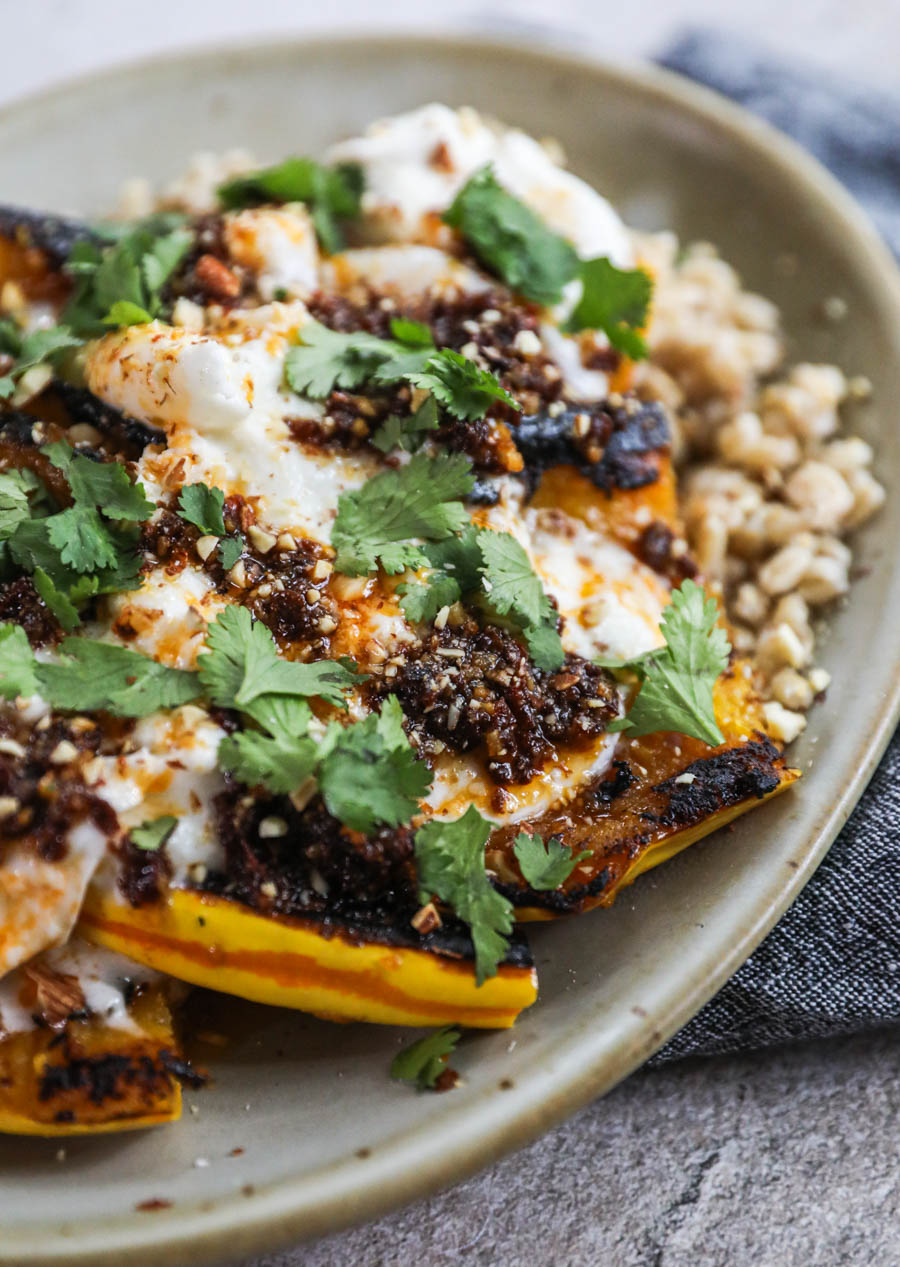 Delicata squash wedges topped with creamy cheese, chile butter, and cilantro.